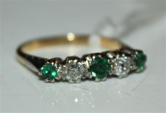 An early to mid 20th century 18ct gold, emerald and diamond ring graduated five stone half hoop ring, size M.(-)